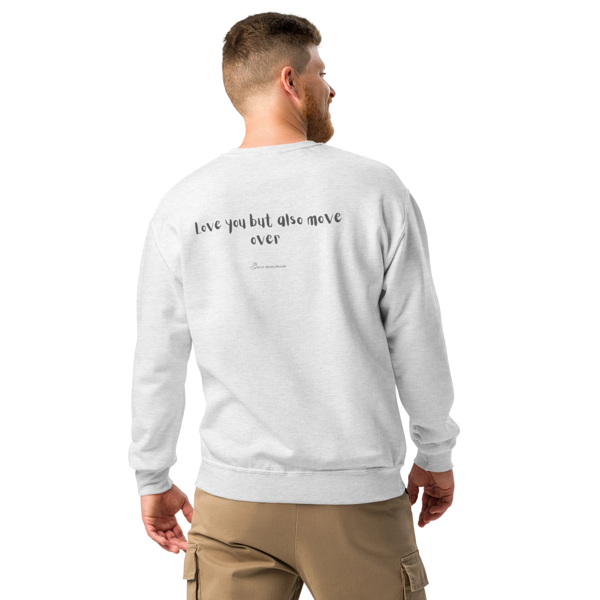 Man wearing a light gray sweatshirt with text on the back, standing against a white background